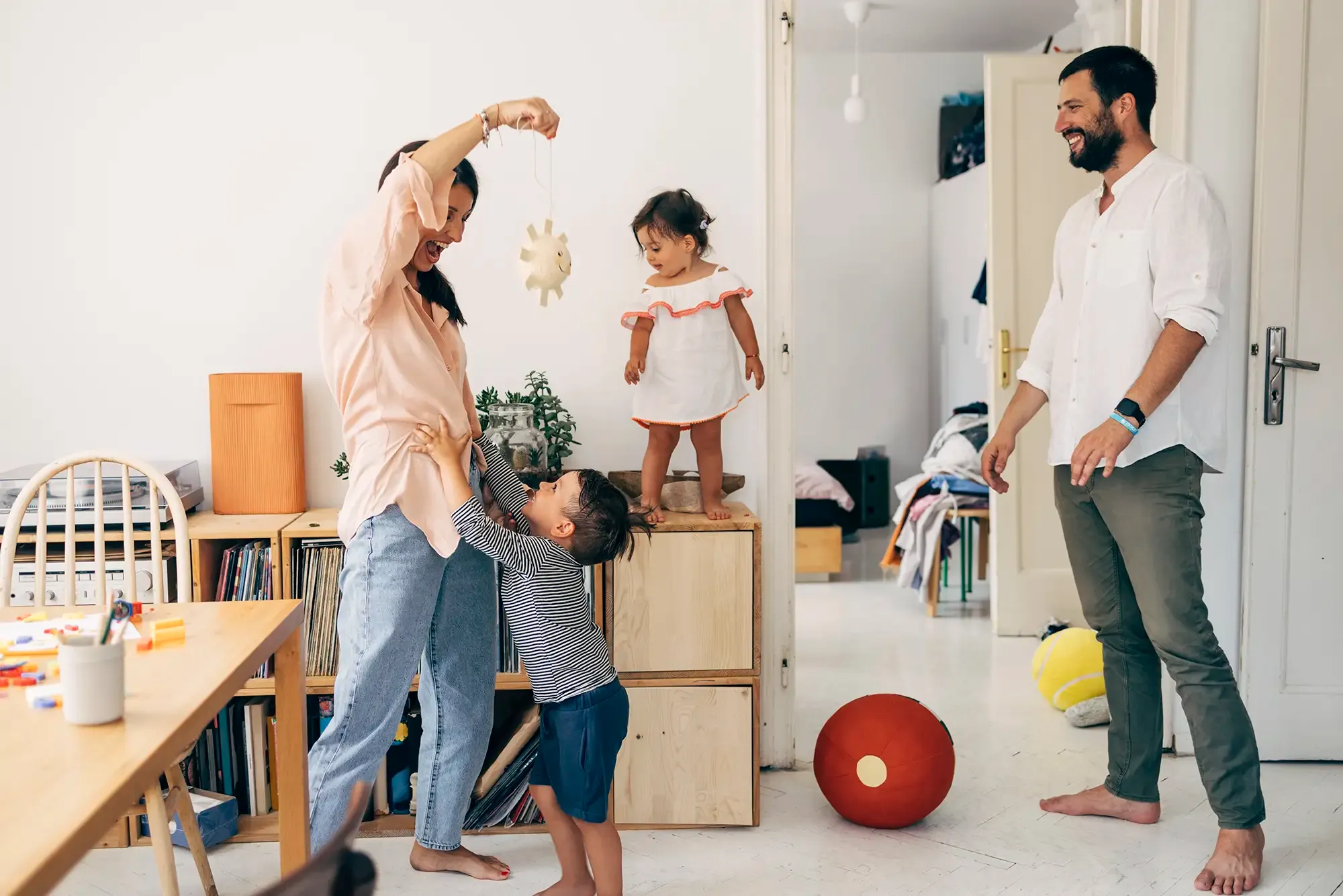 Happy family playing together at home, symbolizing financial security and planning ahead with essential savings accounts.