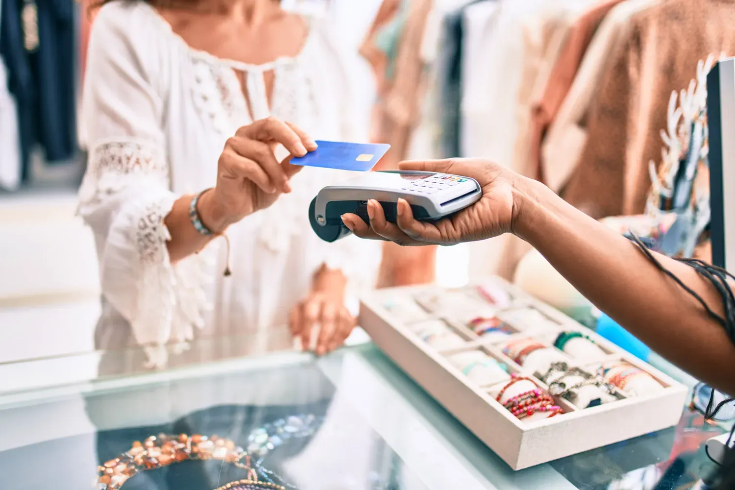 Customer making a purchase with a credit card at a jewelry store, demonstrating how using credit cards responsibly can help build credit.