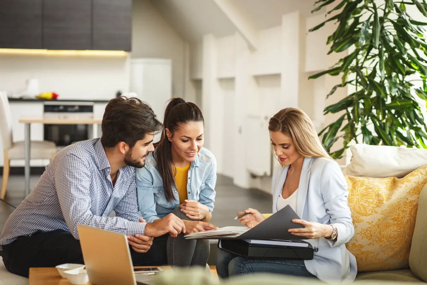 Couple meeting with a financial advisor at home, reviewing documents together to discuss whether a home equity line of credit (HELOC) is the right choice for them.
