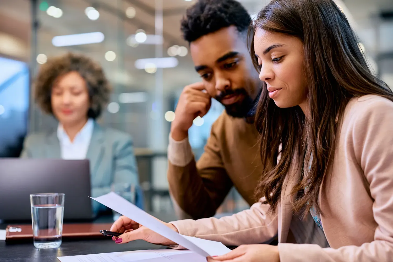 Couple reviewing mortgage documents with a financial advisor, representing when and how to refinance a home loan for better rates or terms.